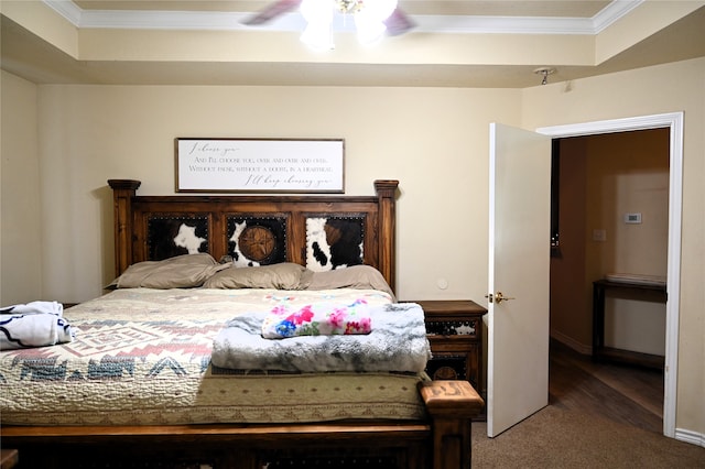 carpeted bedroom with crown molding, a tray ceiling, and ceiling fan