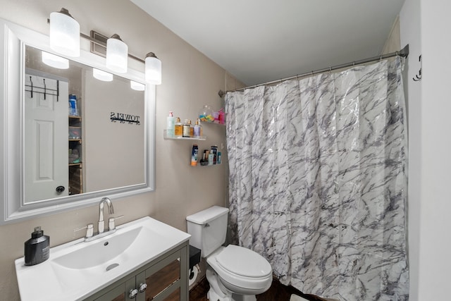 bathroom with curtained shower, vanity, and toilet