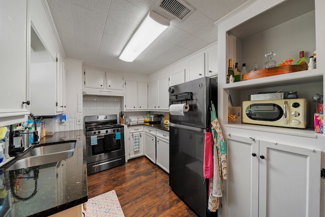 kitchen featuring gas stove, sink, white cabinetry, dark hardwood / wood-style flooring, and refrigerator