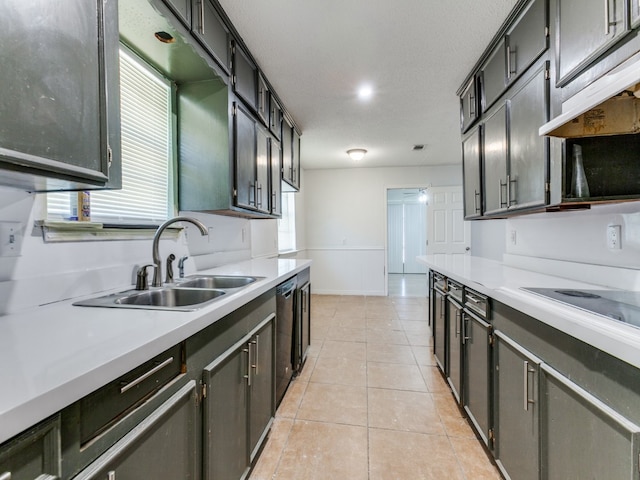 kitchen with light tile patterned floors, a textured ceiling, sink, and a healthy amount of sunlight