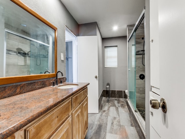 bathroom featuring hardwood / wood-style flooring, vanity, and a shower with shower door