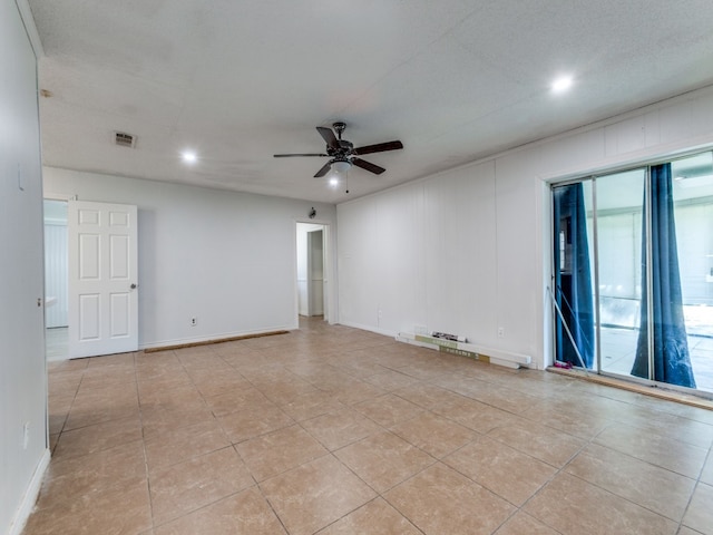 tiled spare room featuring a textured ceiling and ceiling fan