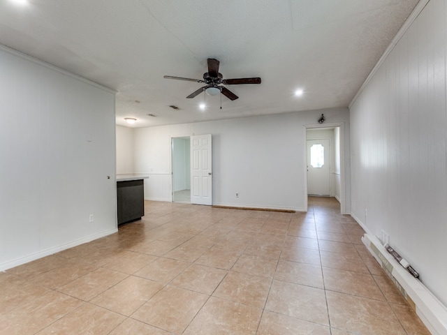 tiled spare room with wooden walls, ornamental molding, and ceiling fan