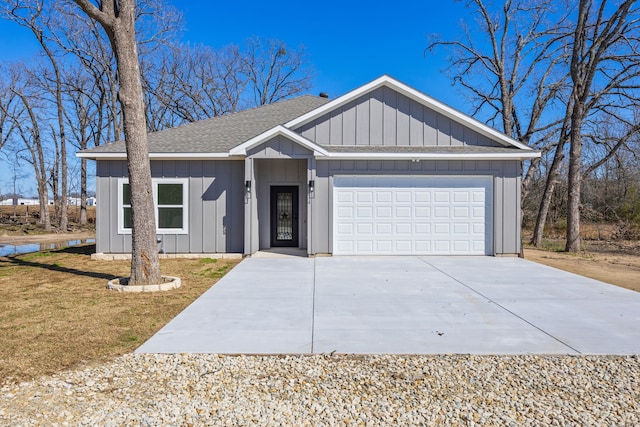 view of front of home with board and batten siding, concrete driveway, a front yard, a shingled roof, and a garage