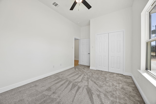 unfurnished bedroom featuring visible vents, carpet floors, baseboards, and a closet