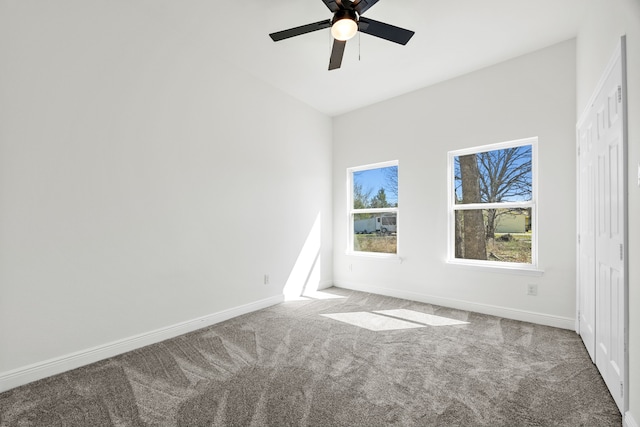 carpeted empty room featuring baseboards and ceiling fan