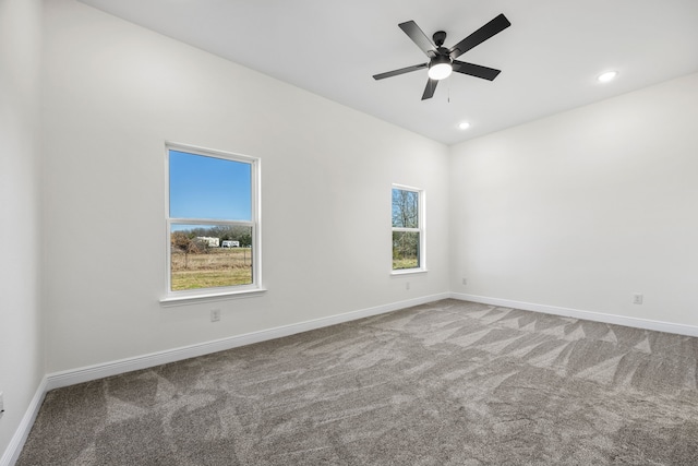 carpeted spare room featuring recessed lighting, a ceiling fan, and baseboards