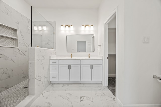 bathroom featuring a marble finish shower, marble finish floor, double vanity, and a sink