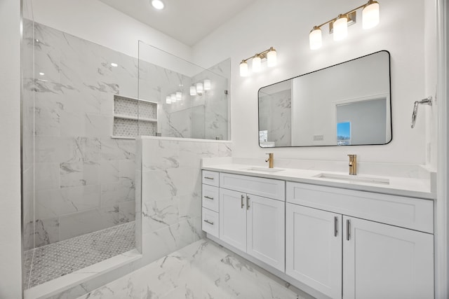 full bath with a marble finish shower, marble finish floor, double vanity, and a sink