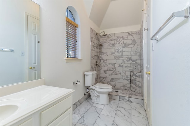 bathroom with toilet, vanity, and tiled shower