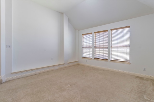 empty room featuring light carpet and vaulted ceiling