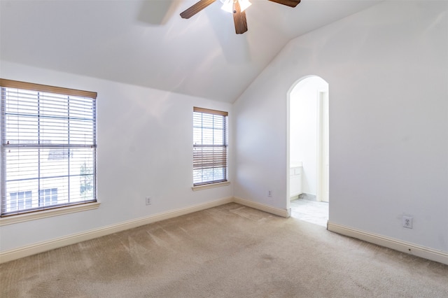 empty room featuring ceiling fan, light colored carpet, and lofted ceiling