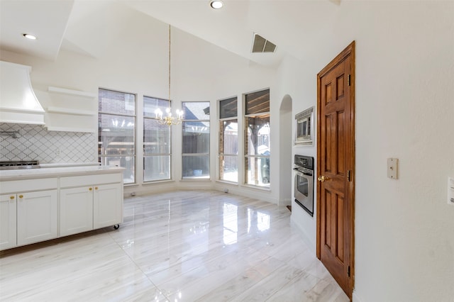 kitchen with pendant lighting, appliances with stainless steel finishes, plenty of natural light, and white cabinetry