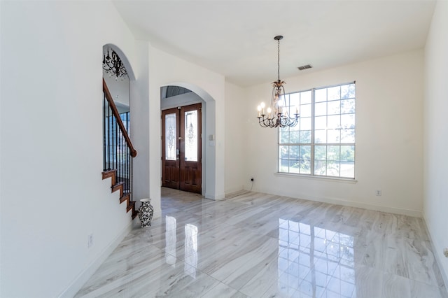 entryway featuring an inviting chandelier and plenty of natural light