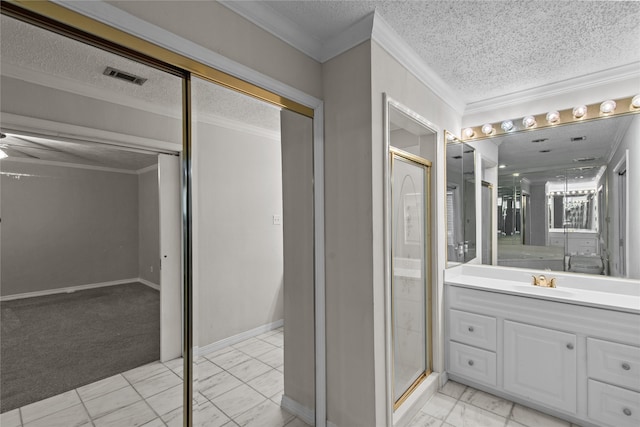 bathroom featuring walk in shower, vanity, ornamental molding, and a textured ceiling