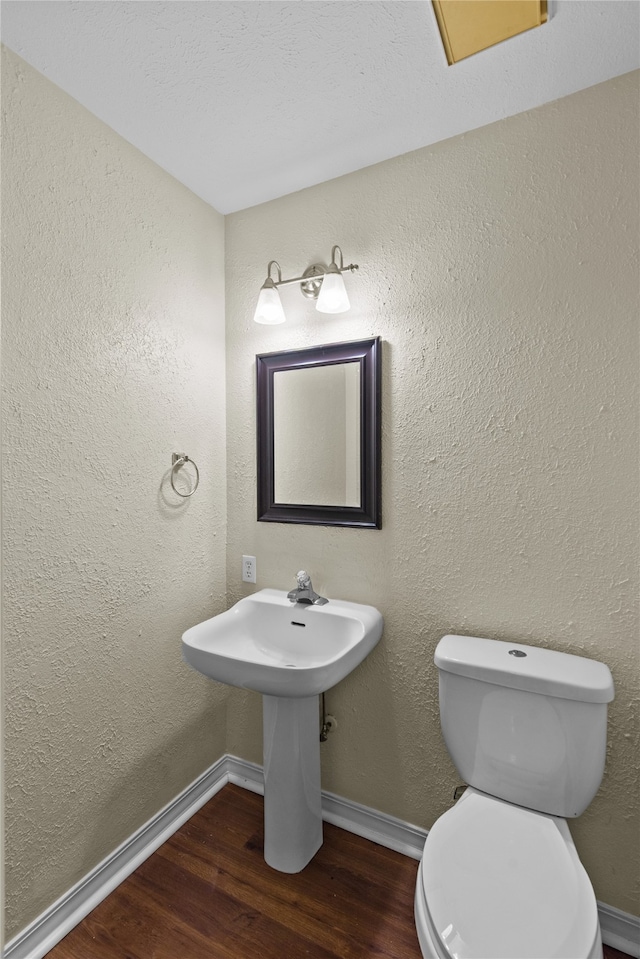 bathroom featuring wood-type flooring and toilet