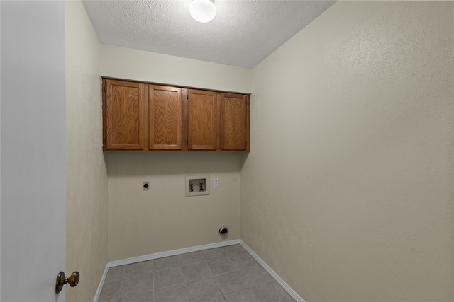 laundry area featuring hookup for a washing machine, cabinets, a textured ceiling, and hookup for an electric dryer