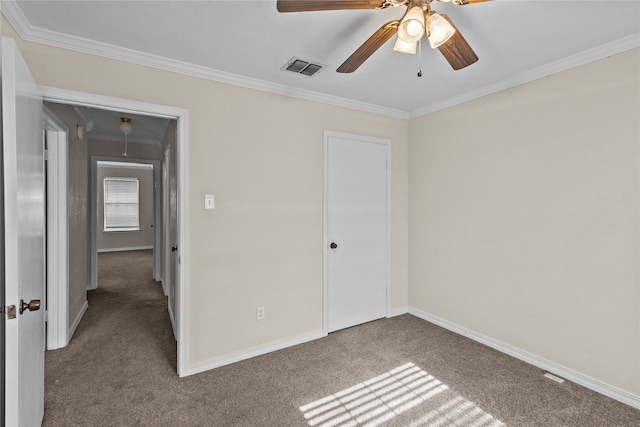 unfurnished bedroom with ceiling fan, a closet, crown molding, and carpet