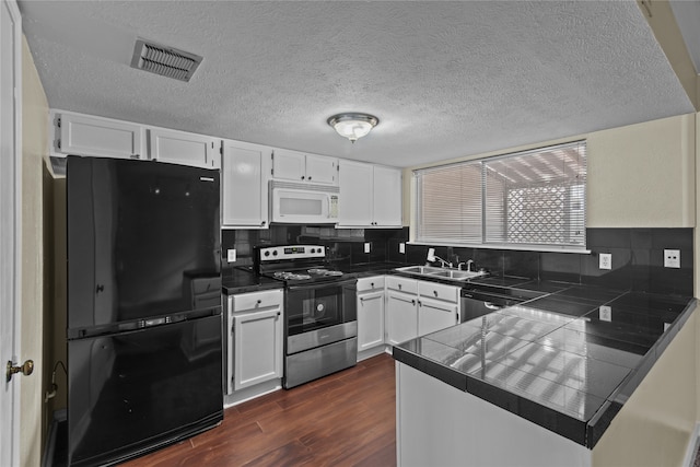 kitchen featuring white cabinets, stainless steel appliances, tile counters, and kitchen peninsula