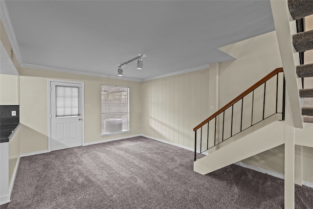 unfurnished living room with carpet, ornamental molding, and track lighting