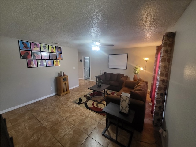 living room with ceiling fan, a textured ceiling, and tile patterned flooring