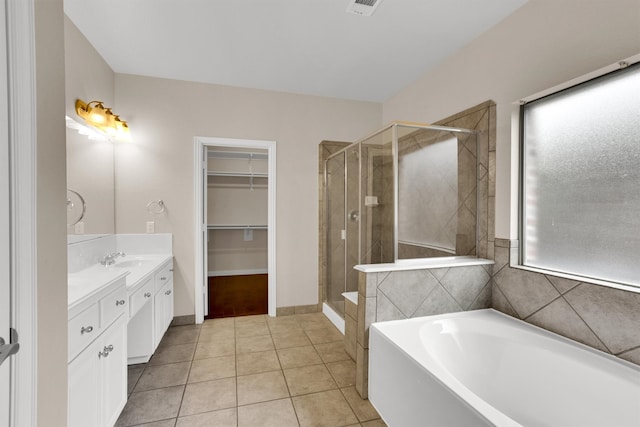 bathroom with tile patterned flooring, independent shower and bath, and vanity