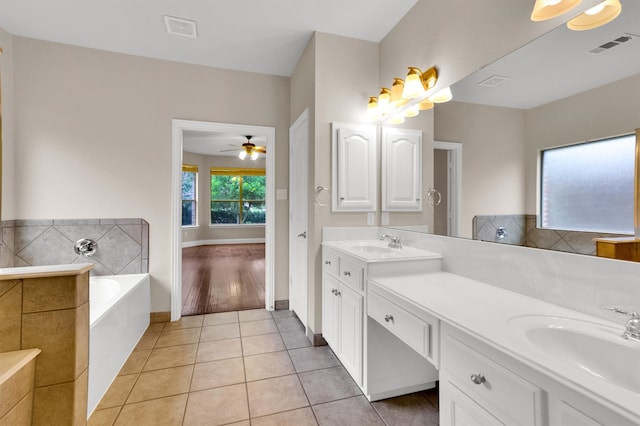 bathroom with a bathtub, tile patterned flooring, vanity, and ceiling fan