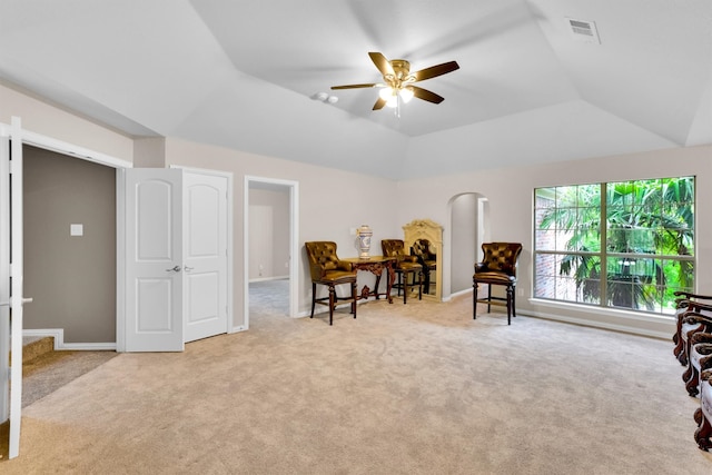 sitting room featuring light carpet, lofted ceiling, a tray ceiling, and ceiling fan