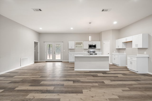 kitchen with dark hardwood / wood-style flooring, stainless steel appliances, and white cabinets