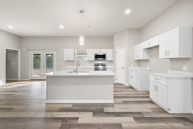 kitchen with white cabinetry, appliances with stainless steel finishes, decorative light fixtures, and sink