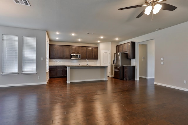 unfurnished living room featuring ceiling fan, sink, and dark hardwood / wood-style floors