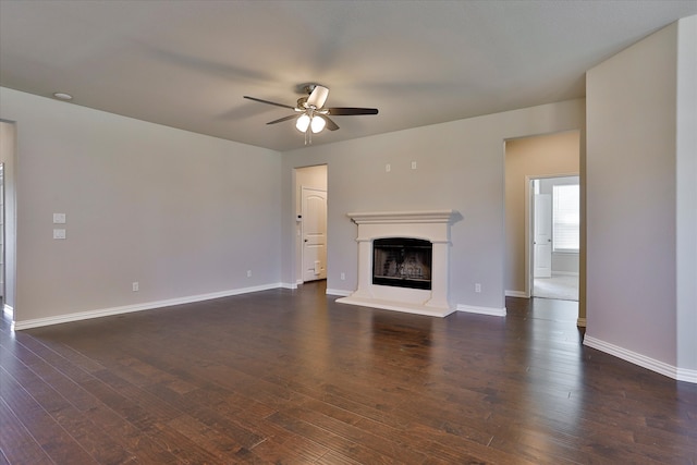 unfurnished living room featuring ceiling fan and dark hardwood / wood-style flooring