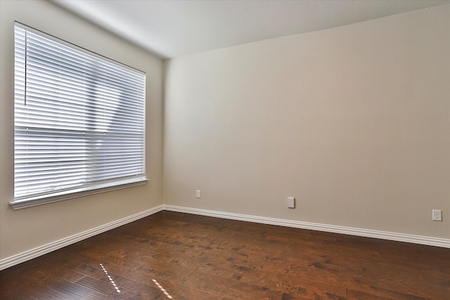 spare room with dark hardwood / wood-style floors and a healthy amount of sunlight