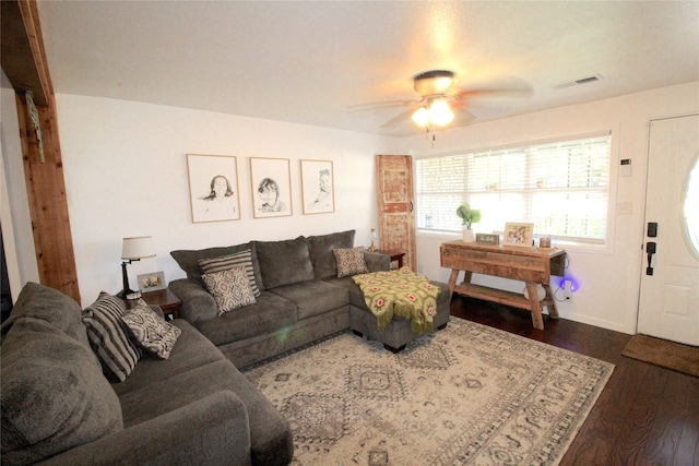 living room with ceiling fan and dark wood-type flooring