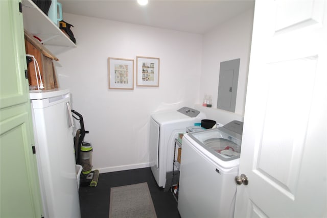 clothes washing area with water heater, electric panel, and washer and dryer