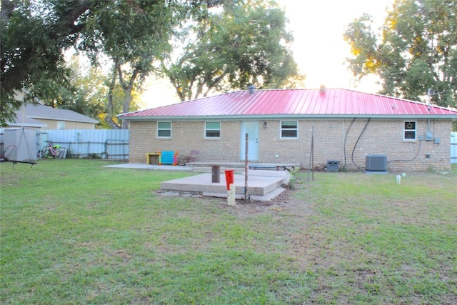 back of house featuring cooling unit, a patio, and a yard