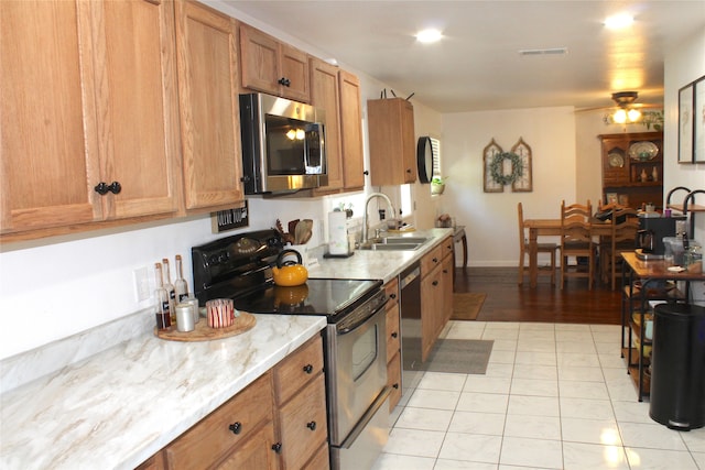 kitchen featuring ceiling fan, light tile patterned floors, stainless steel appliances, and sink