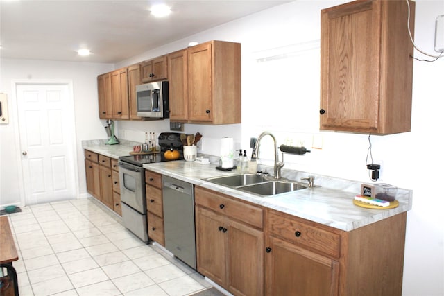 kitchen with sink, light tile patterned floors, and stainless steel appliances