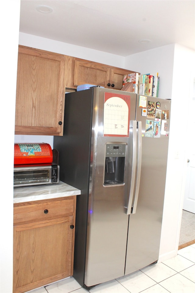 kitchen featuring stainless steel refrigerator with ice dispenser and light tile patterned floors