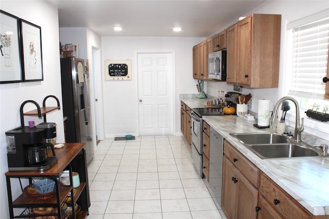 kitchen with light tile patterned floors, stainless steel appliances, plenty of natural light, and sink