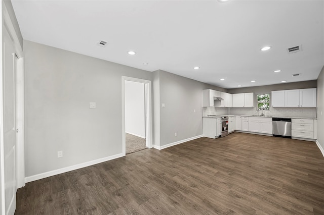 kitchen with appliances with stainless steel finishes, dark wood-type flooring, white cabinetry, and tasteful backsplash