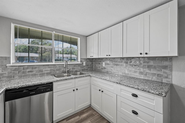 kitchen with white cabinets, stainless steel dishwasher, light stone countertops, and sink