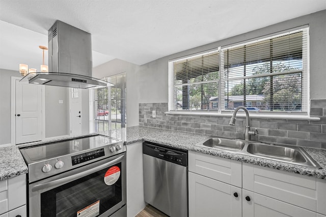 kitchen with sink, dishwasher, island exhaust hood, white cabinets, and range