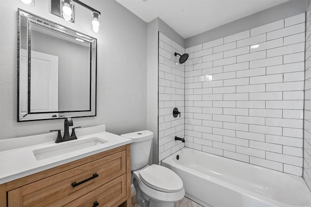 full bathroom with vanity, tiled shower / bath combo, and toilet