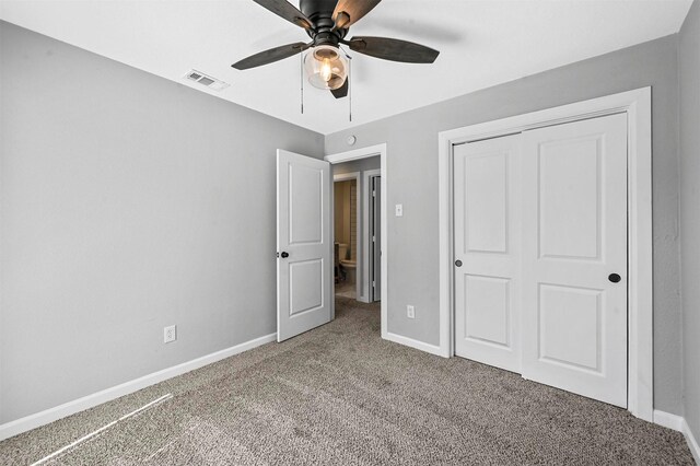 unfurnished bedroom with carpet flooring, ceiling fan, and a closet