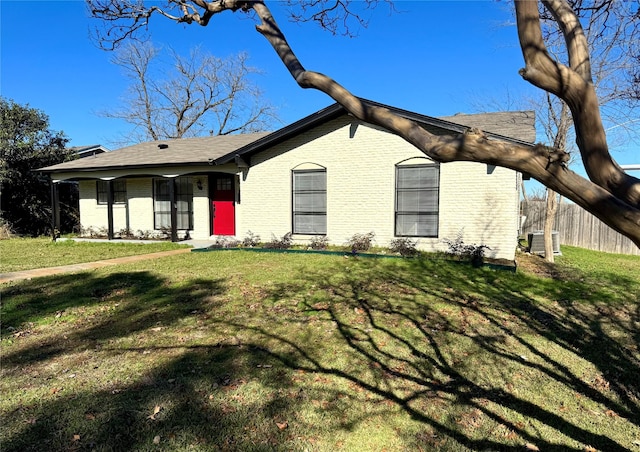 ranch-style home featuring central air condition unit and a front lawn