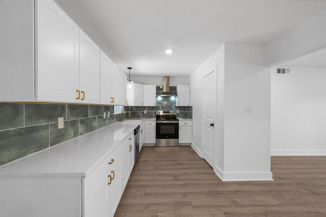 kitchen with decorative backsplash, appliances with stainless steel finishes, hanging light fixtures, and white cabinets