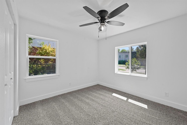 spare room with plenty of natural light, ceiling fan, and carpet