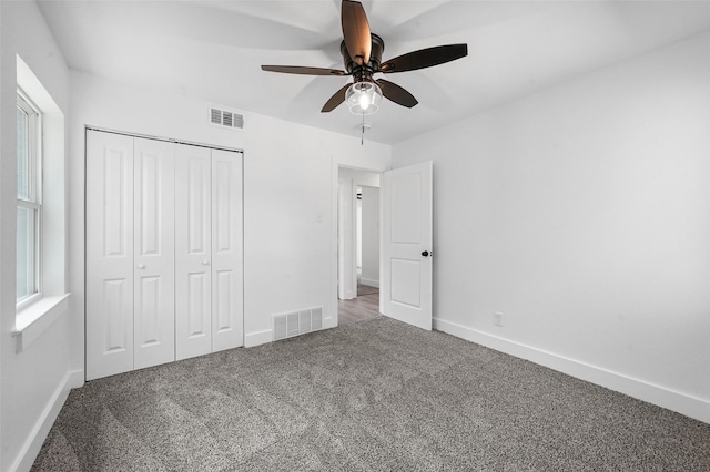 unfurnished bedroom featuring light colored carpet, a closet, and ceiling fan