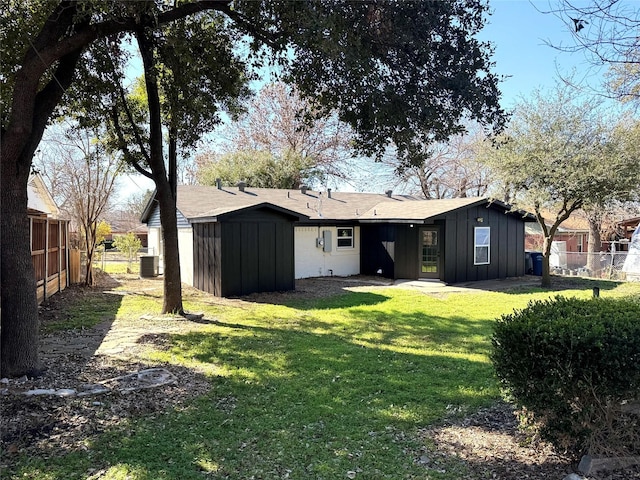 rear view of property with a storage shed, central AC, and a lawn